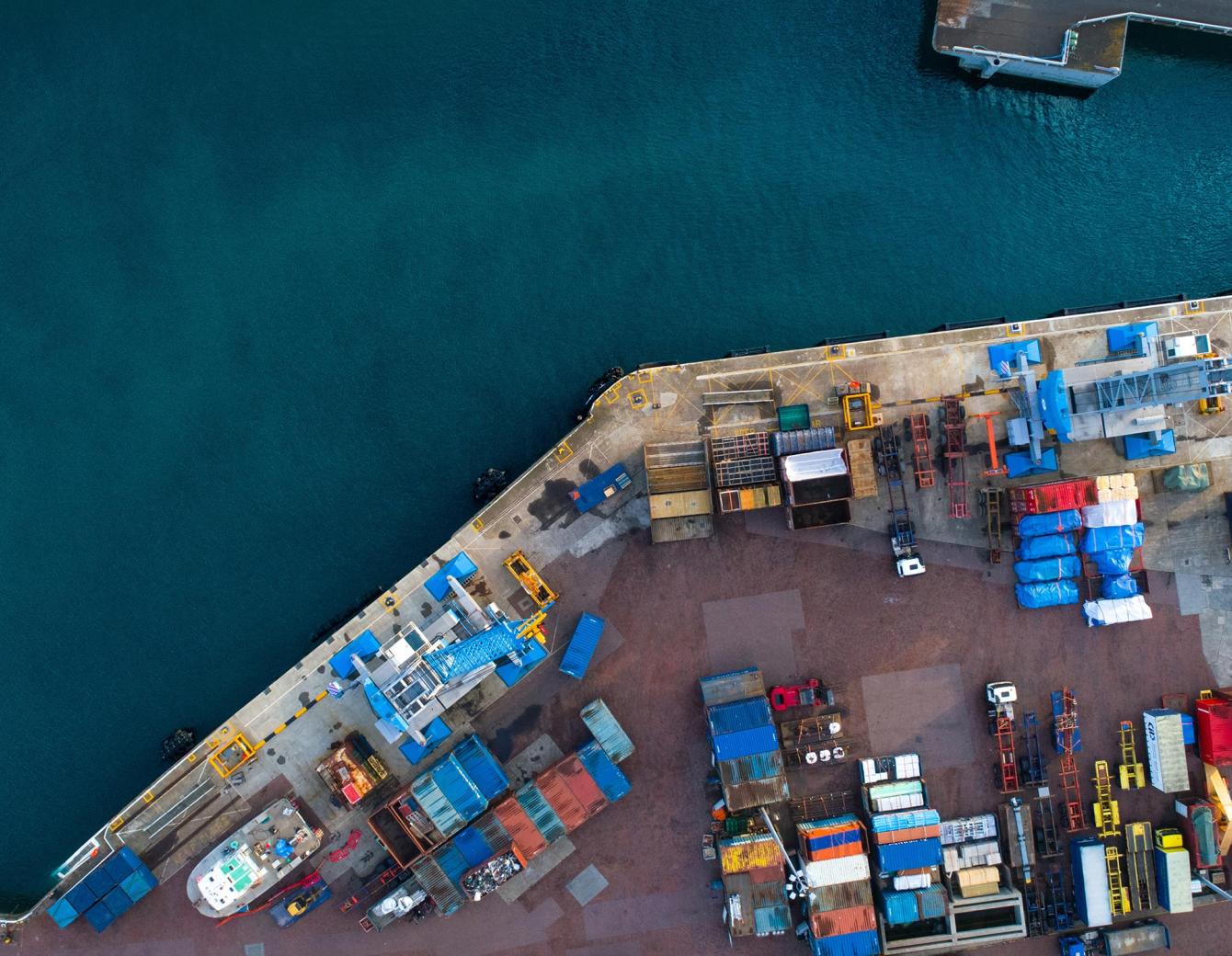 Aerial view of water and dock covered in shipping containers