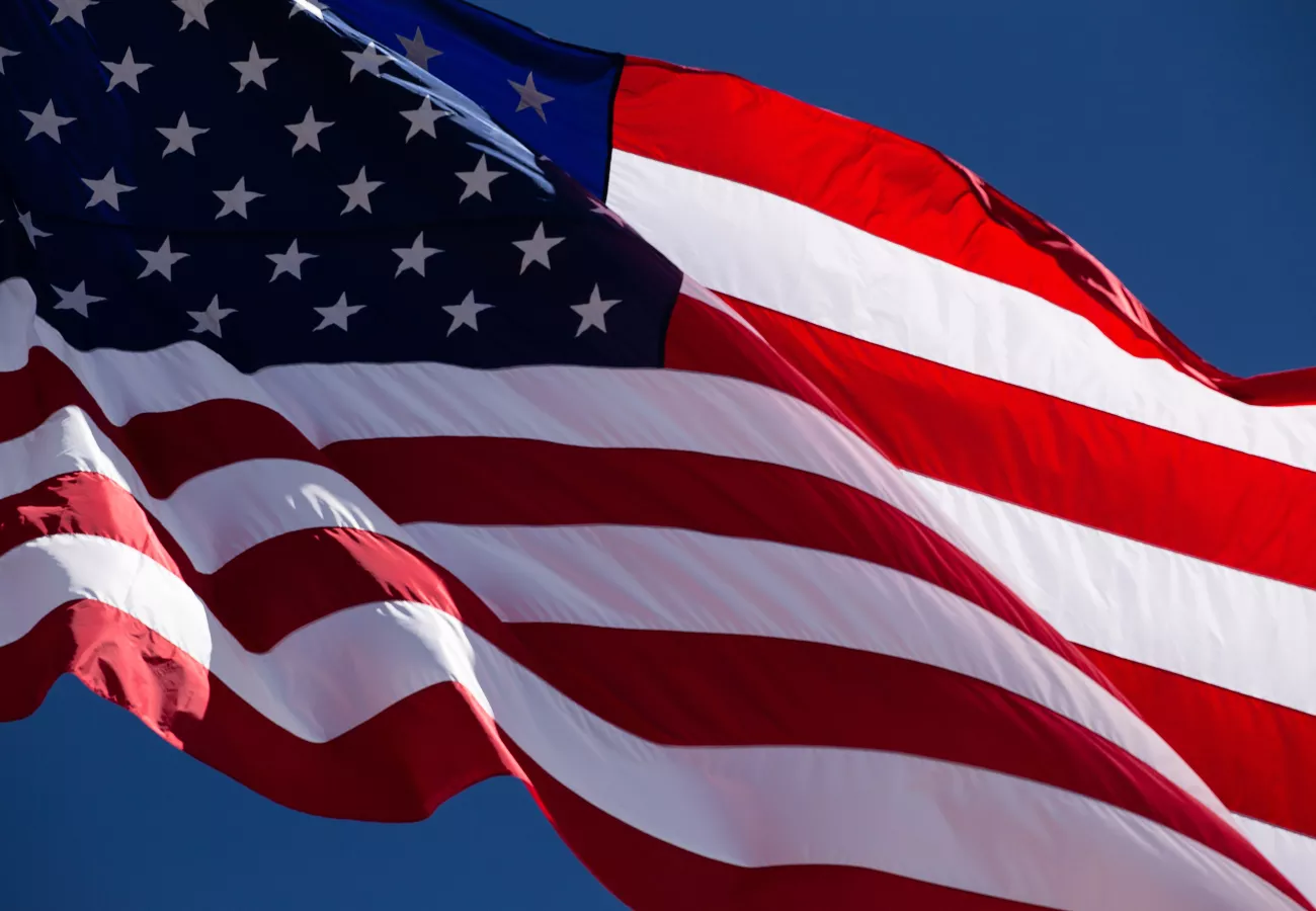 American Flag blowing in wind on blue sky